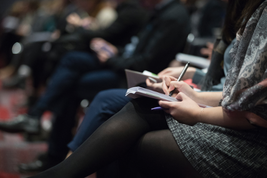 Decorative photo of people taking notes