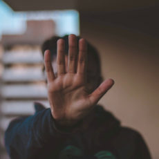 Decorative photo of person holding out their hand in "no" gesture