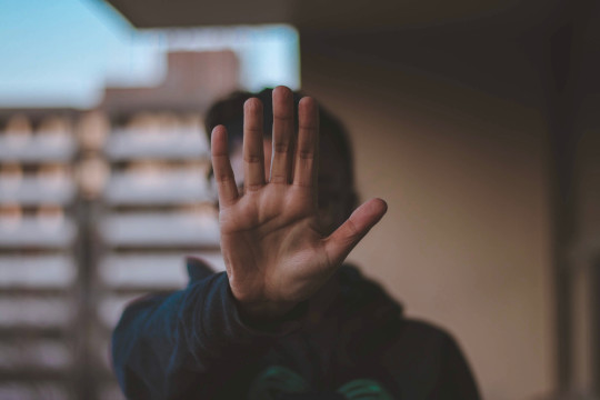 Decorative photo of person holding out their hand in "no" gesture