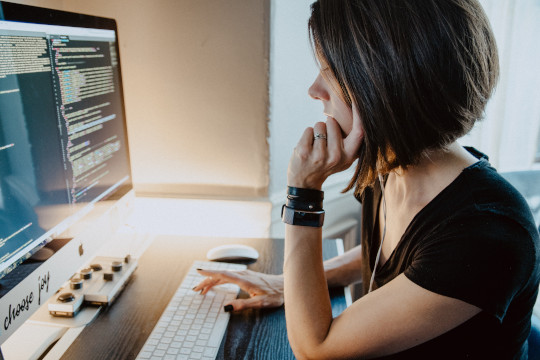 Photo of person at computer coding