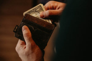 Decorative image of person putting money in wallet