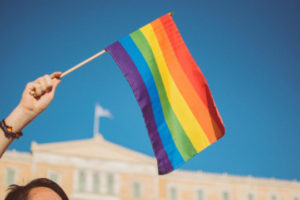 Decorative image of person waving rainbow flag