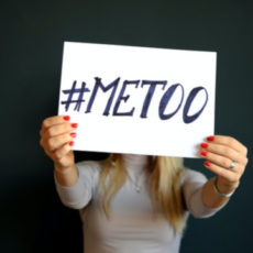 Decorative photo of person holding sign saying "#MeToo"