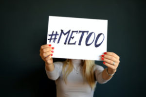 Decorative photo of person holding sign saying "#MeToo"