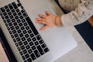 Decorative photo of baby's hand on laptop