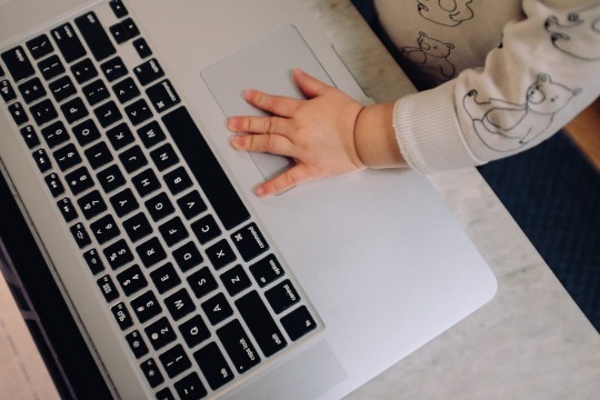 Decorative photo of baby's hand on laptop