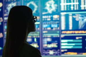 Decorative photo of woman silhouetted against computer displays