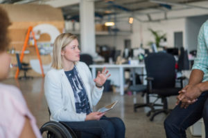 Decorative photo of person in wheelchair talking to colleague