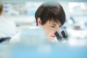 Decorative photo of person looking into microscope