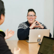 Decorative photo of two people talking with laptops