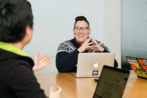 Decorate photo of two people talking with laptops