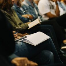 Decorate photo of people taking notes in audience