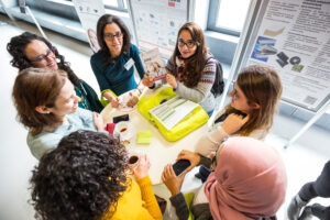 Decorative photo of people discussing in front of a whiteboard