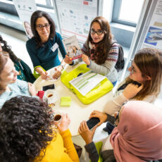 Decorative photo of people discussing in front of a whiteboard