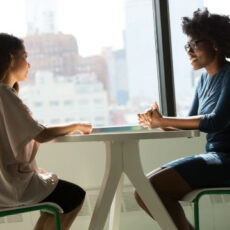 Decorative photo of two people talking in front of window