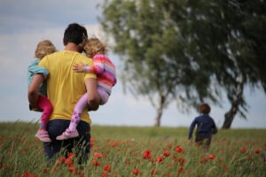 decorative photo of parent and kids in a meadow