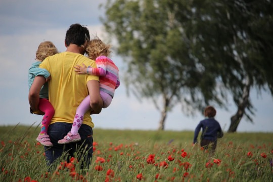 decorative photo of parent and kids in a meadow