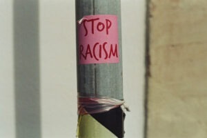 Decorative photo of post it note reading "Stop Racism"