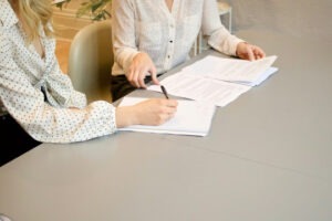 decorative photo of two people at a table discussing documents