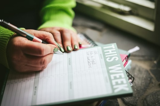 decorative photo of person writing a weekly overview