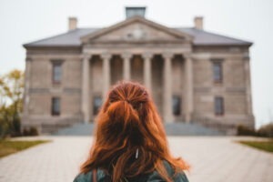 Person standing in front of a classical building