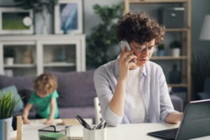 Person working in the foreground while kid is playing in the background