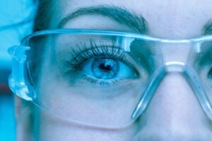 Decorative photo of researcher close up through saftey goggles