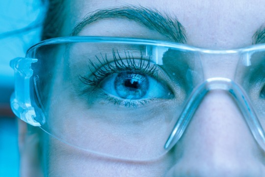Decorative photo of researcher close up through saftey goggles